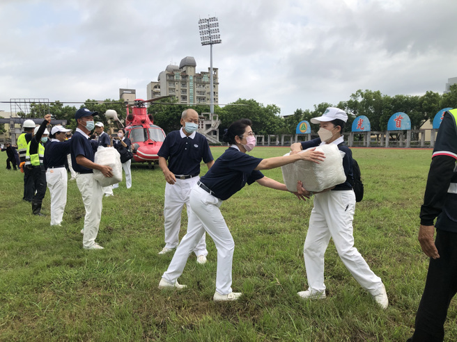慈济志工、南投市的嘉和与营南社区共出动近50名志工，在现场帮忙包裹清点物资，并协助送上直升机。(慈济提供)
