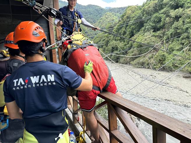 塔罗湾溪暴涨，饭店泡在水中，98名游客受困庐山温泉，搜救队架设溜索展开救援。（消防署提供／杨静茹南投传真）