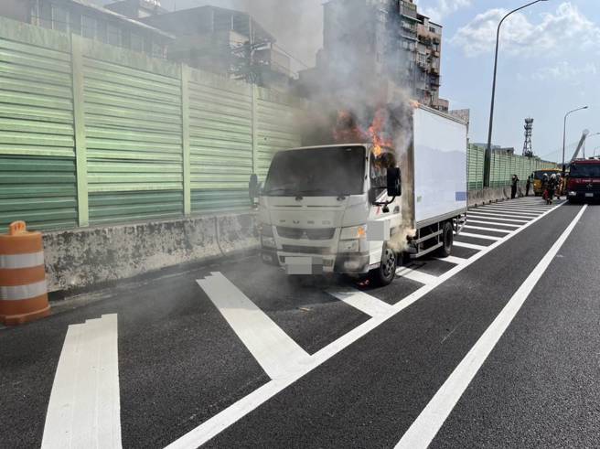 今7日下午15时5分许国道一号北上8.9公里处发生一起火烧车事故，一辆超商物流车行驶间驾驶座忽然冒烟，驾驶赶紧将车辆停靠路边，随即冒出火烟，车上2人紧急下车逃生。（图／新北消防局提供）