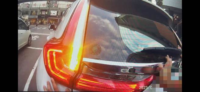 兩名員警以徒手推車的方式，幫忙將車輛推到路邊解危。（翻攝照片／林郁平台北傳真）