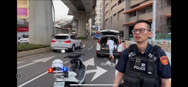 兩名員警以徒手推車的方式，幫忙將車輛推到路邊解危。（翻攝照片／林郁平台北傳真）