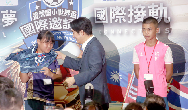 副总统赖清德（中）9日出席「2023台湾国小世界杯国际邀请赛」记者会，并为出赛的小球员披上战袍。（范扬光摄）