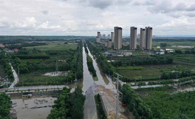 卡努颱風將致大陸東北再現強降水 雨要下到15日。圖為黑龍江省哈爾濱市道外區黃家崴子附近長江路8日封閉禁行，積水數百米長，工作人員看守。（新華社）