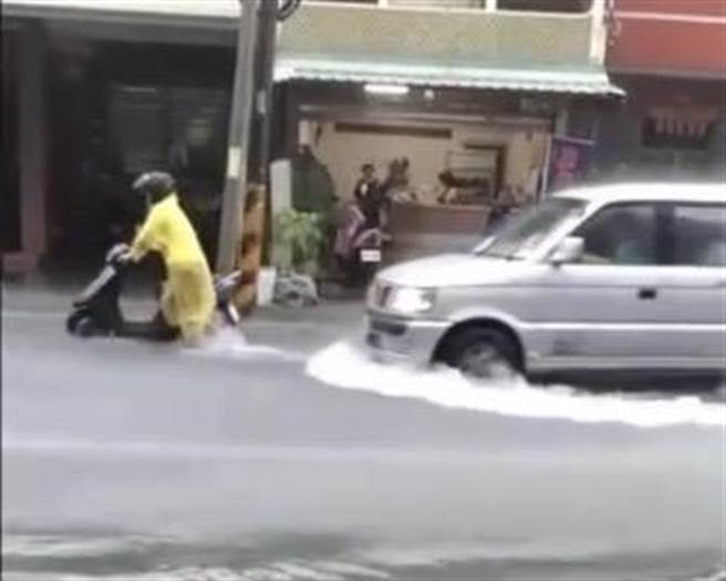 騎士不得不在雨中牽著機車涉水。（李中岑提供／張毓翎台南傳真）