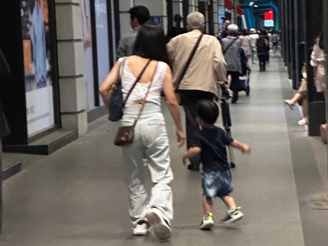 石英走在前方，儿媳带着孙子在后方散步，画面相当温馨。（图／读者提供）