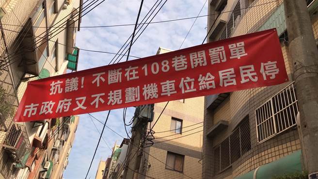 新竹市光华二街108巷住户挂起红布条，抗议在巷弄内频开罚单，却不规画机车停放空间。（截自杨玲宜脸书）