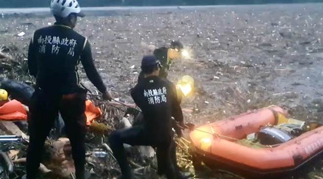 仁爱消防分队出动橡皮艇救援在万大水库边3名农民，却遭一望无际漂流木团团包围带往岸边受困，合力将橡皮艇拉上岸。（民眾提供／杨静茹南投传真）