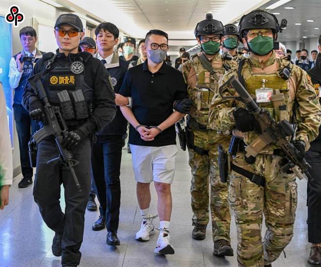 「88会馆」负责人郭哲敏逃亡海外9个月，上月于泰国落网。10日下午被遣返回台，大批荷枪实弹警员戒护押解。（本报资料照片）