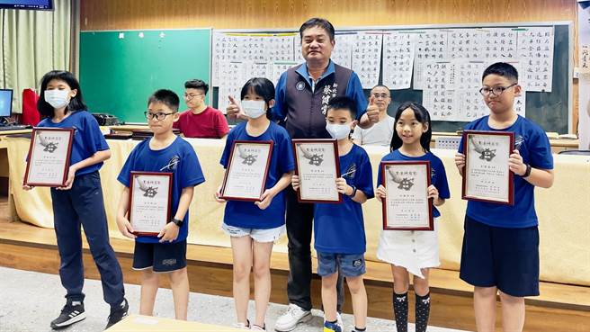 暑期書法研習營的推手之一，新北市議員蔡健棠與獲得完訓證書的小朋友合影留念。（呂健豪攝）