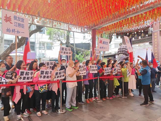國民黨總統參選人侯友宜11日到豐原慈濟宮參拜，支持者高舉「要和平，不要戰爭」標語。（陳淑娥攝）