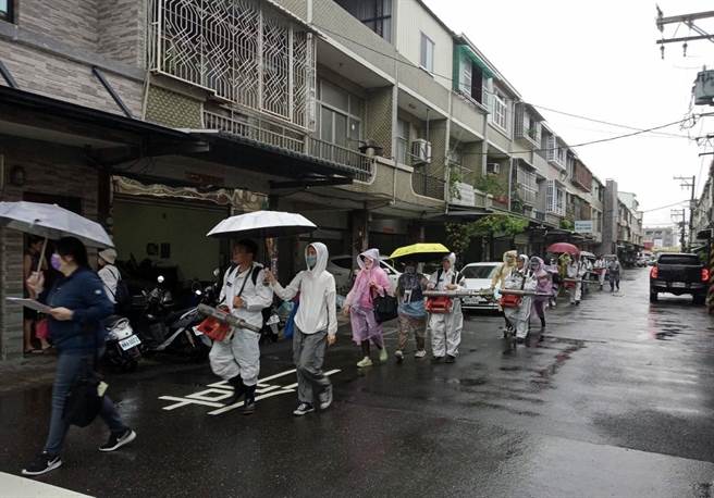 連日來台南市區下著大雨，但防疫人員仍冒著雨進行室內噴藥。（衛生局提供／洪榮志台南傳真）