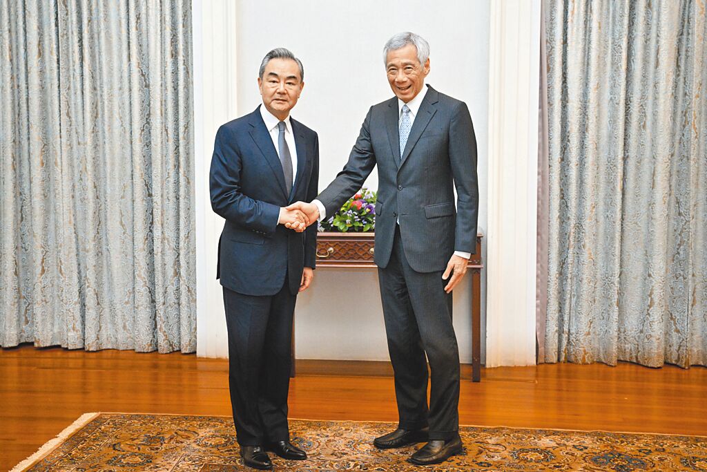 中共中央政治局委員、中國外交部長王毅（左）訪問新加坡，11日會見新加坡總理李顯龍。（新華社）