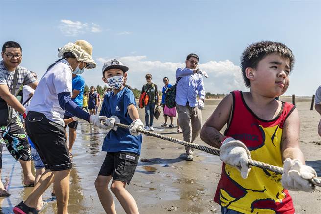新竹县竹北市新月沙湾「梦迴牵罟」活动，大小朋友牵绳体验传统捕渔文化。（罗浚滨摄）