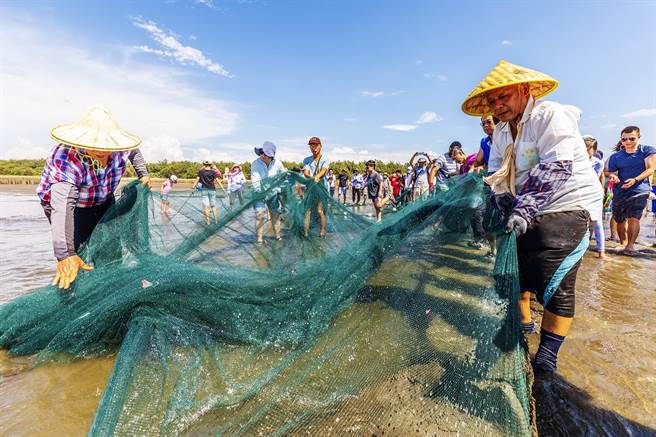 新竹县竹北市新月沙湾「梦迴牵罟」活动，大小朋友全力将渔网拖上岸。（罗浚滨摄）