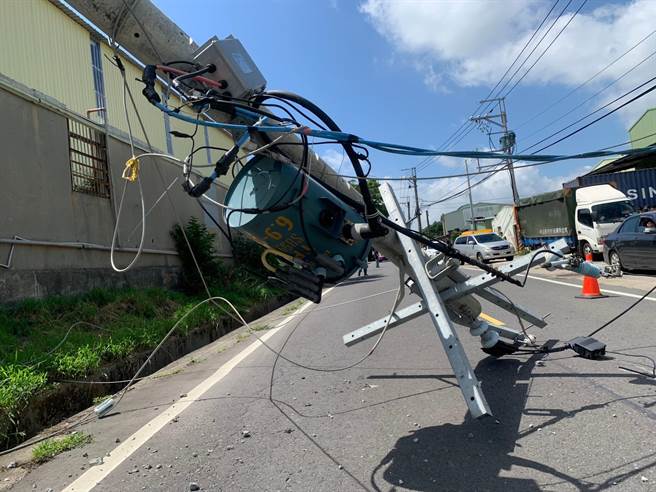 被撞断的电线杆斜躺在道路中间，造成交通受阻。（林口区公所提供）