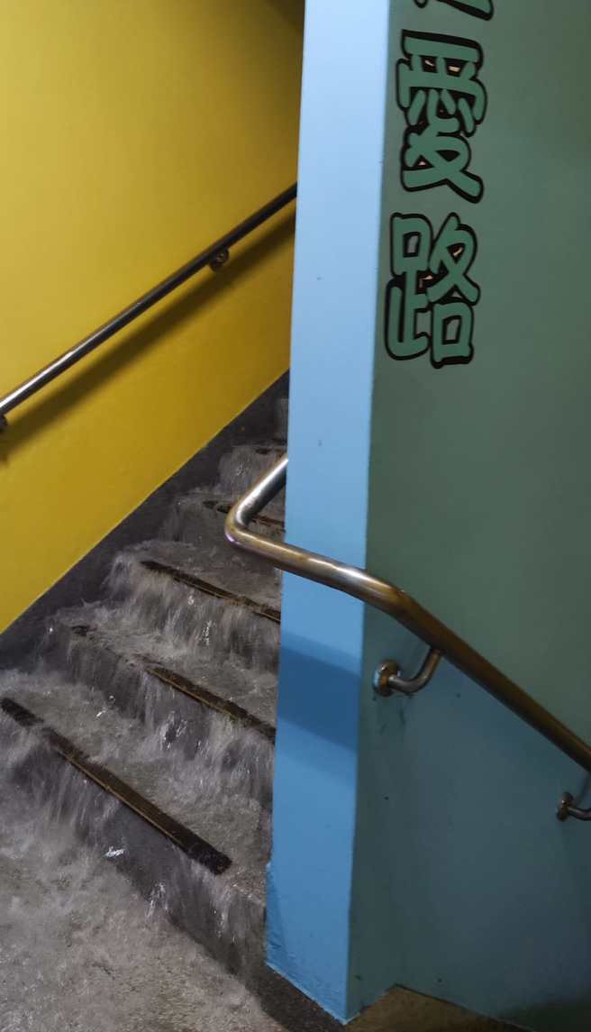 蘆竹區婦幼館地下室樓梯變瀑布，雨水傾瀉而下，室內地板全積水。（網友授權提供）