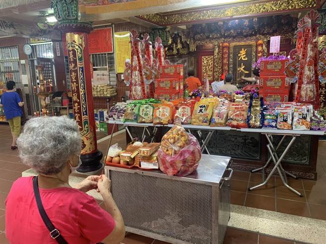 民眾领取结缘的食品后，进行祭拜好兄弟的仪式。（徐佑升摄）