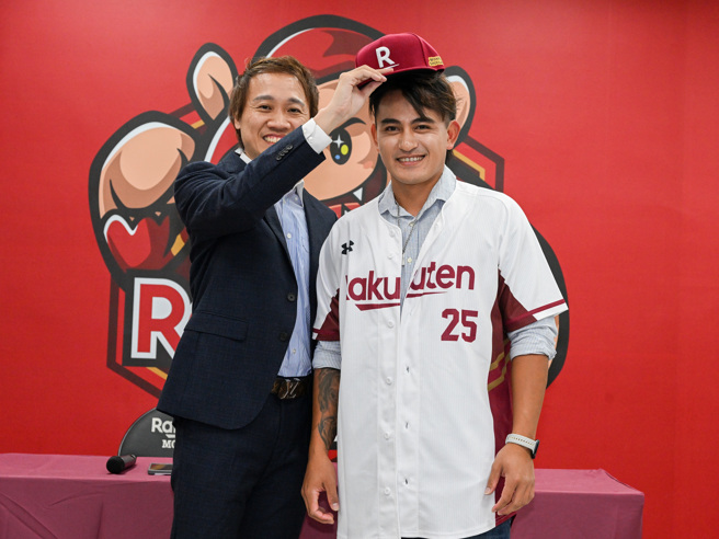 乐天桃猿领队浦韦青（左）为林子伟戴上球帽。（陈麒全摄）