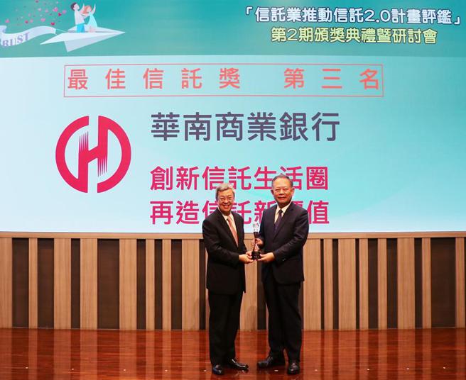华南银行获金管会「第2期信托业推动信托2.0计画评鑑」-「最佳信托奖」绩效优良银行，由行政院院长陈建仁(左)颁奖，华南银行董事长张云鹏(右)代表受奖。（图／华南银行提供） 