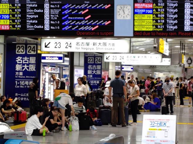 日本靜岡縣局部地區16日清晨起下大雨，導致東海道新幹線大約誤點5個多小時，圖為中午東京品川車站等待搭車人潮；總計16日約有30萬5000名乘客行程受到影響。（圖／中央社）
