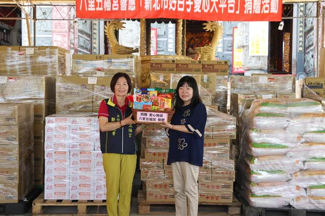 八里五福宫主委郑戴丽香（左）连续七年捐赠普渡物资  由新北市社会局副局长吴淑芳代表受赠。(黄敬文翻摄)