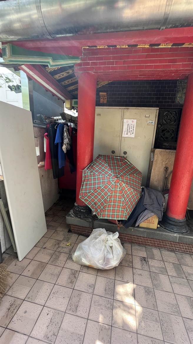 街友在土地公庙旁用雨伞围出生活空间，甚至在一旁晾晒衣服，议员要求社会局加强辅导。（郑功进提供／张亦惠台中传真）