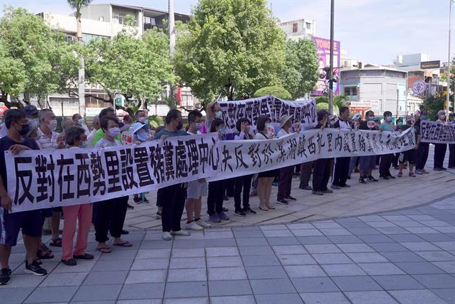 县府18日举行「畜牧业粪尿多元利用资源化共同处理中心BTO前期作业暨履约监督管理计画案场址遴选会议」，吸引近百乡亲到场抗议，高举布条反对兴建。。（吴建辉摄）