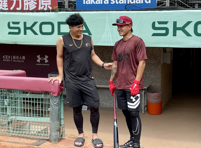 统一狮林岱安（左）与效力乐天桃猿的堂弟林子伟相见欢。（毛琬婷摄）