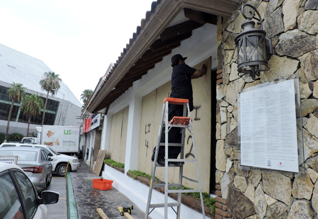 2023年8月18日，4级飓风希拉里即将抵达美国加州，一名男子用木板封住了一家餐厅的窗户。（路透社）