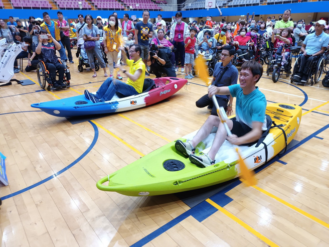 今年亞帕運輪椅網球國手唐兆漢（右下）透過AR體驗跟永達保險經紀人副總經理李忠約（黃衣）尬划船。（新北市體育處提供）