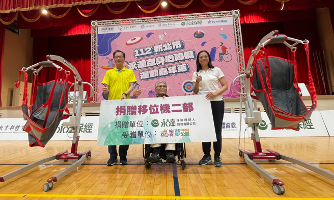 永達保險經紀人副總經理李忠約（左）在新北市身心障礙嘉年華捐贈兩台「移位機」，讓重度不便的身障朋友也能參與運動。（李弘斌攝）