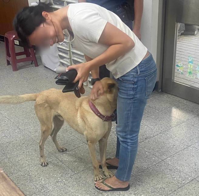 林女到派出所，见到爱犬「水管」时的画面。（照片 / 警方提供）
