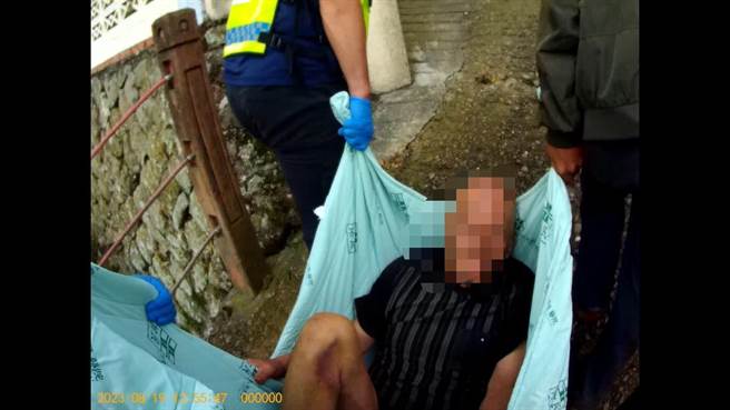 独居老翁因跌倒无力，满身排泄物，最后由警方与消防人员合力将老翁从山坡下住屋处，以人力徒步扛至山坡上的救护车。（竹崎分局提供∕吕妍庭嘉义传真）