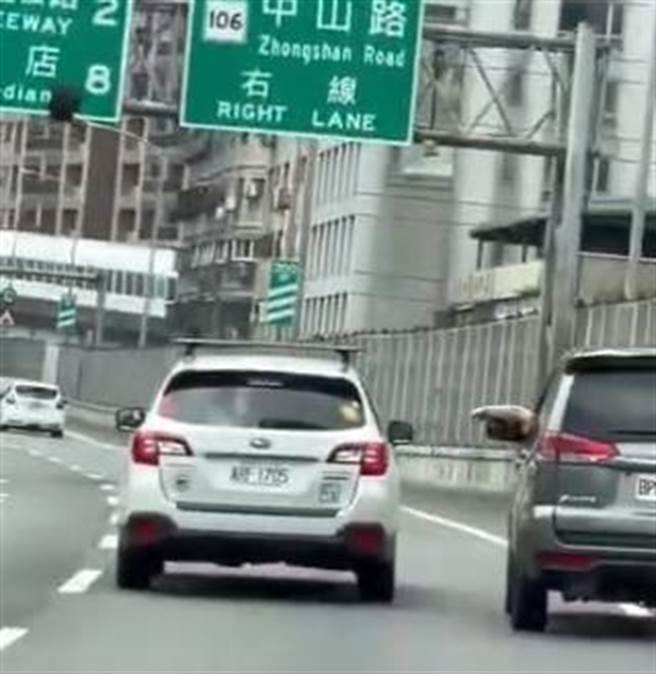 银色箱型车从路肩超车，驾驶摇下车窗，对着白色休旅车驾驶比手画脚叫嚣。（翻摄脸书爆料公社）