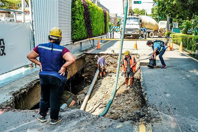 县政七街建案工地旁路基塌陷，经会勘后研判工地设置的止水桩不够密集，加上近来豪雨造成，建商灌浆填补孔洞，水公司也派员修復管线。（罗浚滨摄）