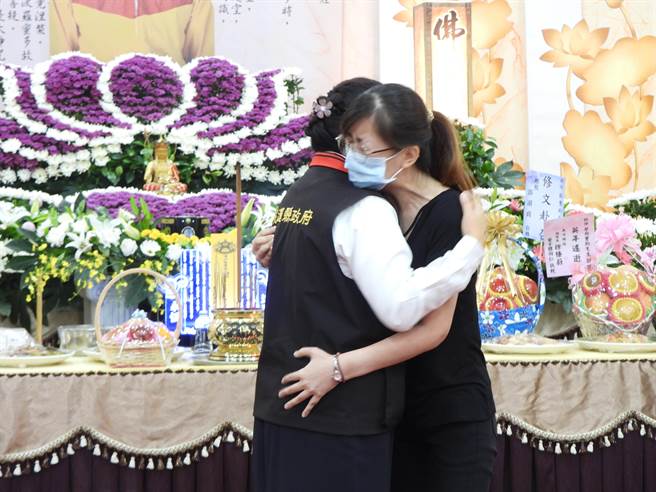 花莲县消防局特种搜救大队小队长蔡玺钧月初赴瑞士受训却猝死异乡，家属今在花莲市殡仪馆举办公祭，县长徐榛蔚（左）前往致哀，并拥抱难过的蔡妻（右），给予最大的安慰。（罗亦晽摄）