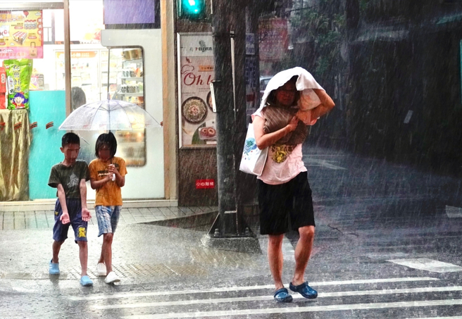 氣象局針對新北等14縣市發布大雨特報，新北市午後下起滂沱大雨，宛如黑夜。（陳信翰攝）