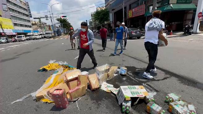 一群移工清除散落在彰化市中央路与中华西路口的饮料。（民眾提供／孙英哲彰化传真）