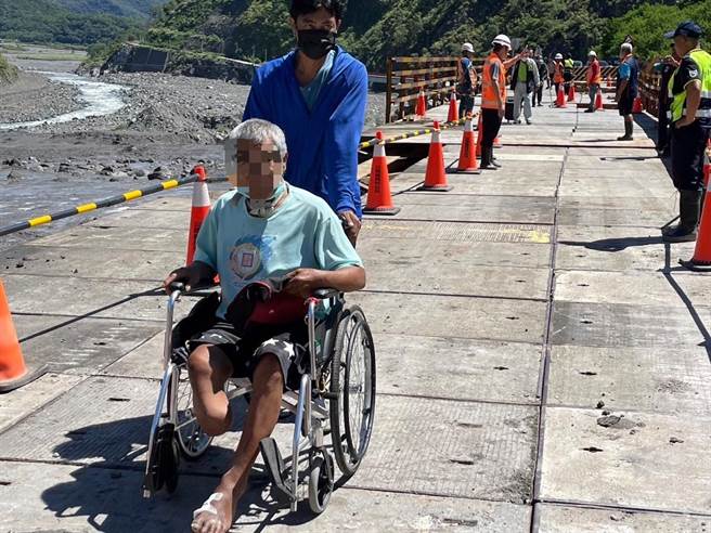 台20线明霸克露桥河床涵管便道22日晚间遭土石流覆盖，公路总局甲仙工务段今早6时进驻全吊式吊车，将修復中的钢便桥紧急搭设木工板，上午10时完成后已开放通行，有居民紧急陪伴家长下山就医。（高雄市原民会提供／林雅惠传真）