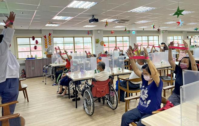楠梓区日间照顾中心专业治疗师带领长辈手部健康操。（图片来源：高雄市卫生局提供）