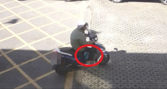 杨男骑车离去时，假踏垫上多了一顶蓝色安全帽。（翻摄画面）