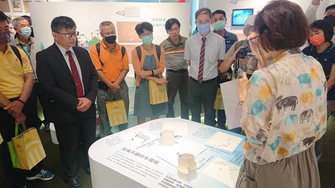 交通部中央气象局局长程家平（黑西装者）聆听导览员讲述「流域共构：云嘉南百年水利与环境特展」内容。（程炳璋摄）