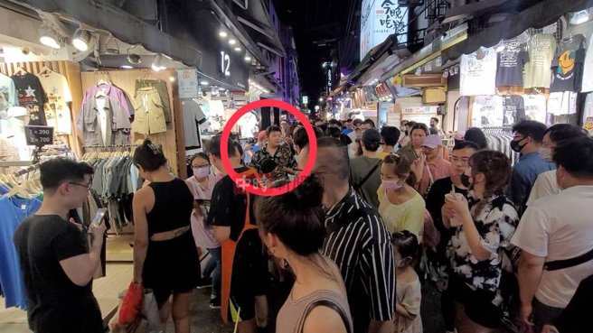 男子带蟒蛇逛士林夜市，民眾热情围观。（游定刚拍摄）