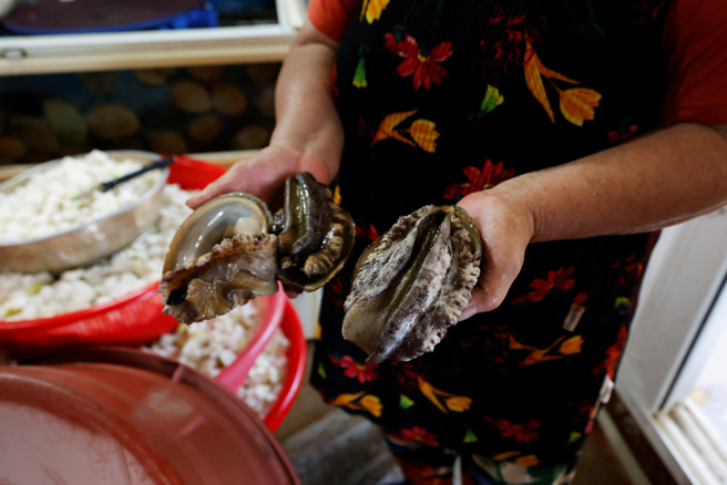 南韩海女23日展示捕获的海鲜。（路透）
