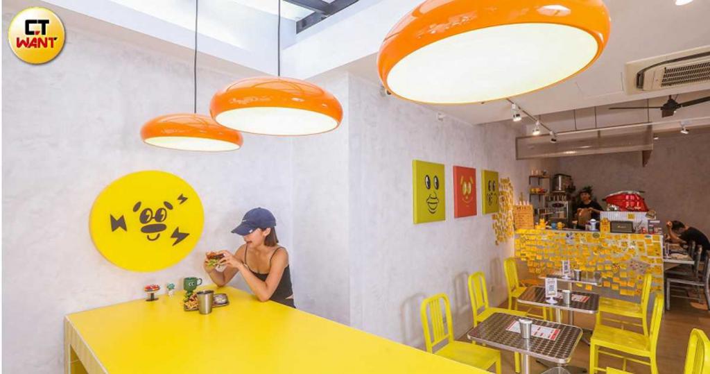 店內以鮮明的黃、橘色營造視覺亮點，牆上笑臉Logo是許多客人最愛的打卡背景。（圖／趙文彬攝）