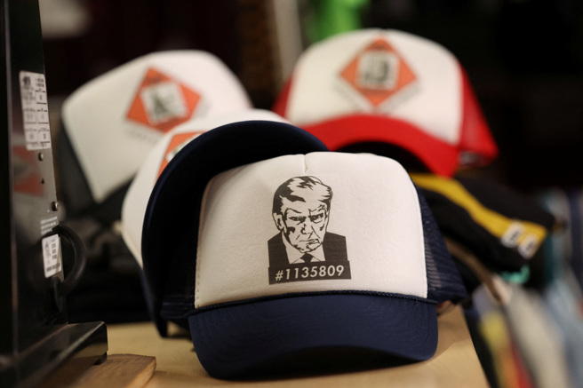 美國前總統川普在監獄投案拍攝的歷史性檔案照被製成各種周邊小物。（圖／路透社）