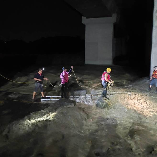 竹山两钓友昨晚因溪水暴涨受困沙洲，竹山分队利用双节梯成功让两人安全上岸。（南投县消防局提供）