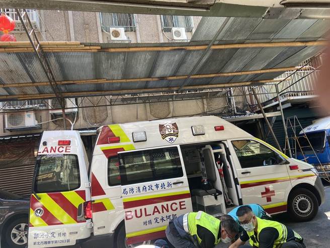 张姓工人27日上午于新北市板桥区大同街搭设棚架，因棚架破裂採空，从2楼坠落到地面，警消正替他包扎救治。（民眾提供）