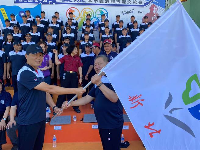 新北市副市長朱惕之授旗給即將赴南投廬山參賽的義消代表隊，由義消總隊長蔣根煌代表受贈新北市旗。（高鈞麟攝）