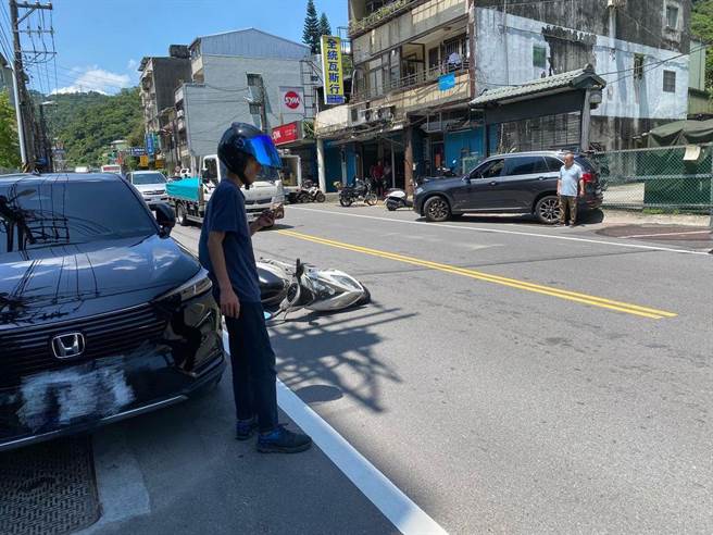 张男摔车后，自行爬起，而中年男子也下车察看，2人隔着马路面面相覷。（翻摄脸书社团）